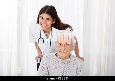 Portrait von Happy Ärztin mit behinderten älteren Patienten im Krankenhaus Stockfoto