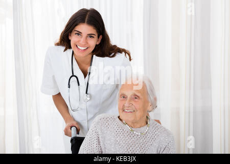 Portrait von Happy Ärztin mit behinderten älteren Patienten im Krankenhaus Stockfoto