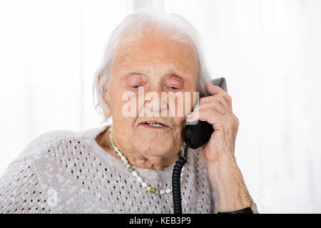 Portrait der älteren Frau, die Konversation auf dem Festnetztelefon Stockfoto