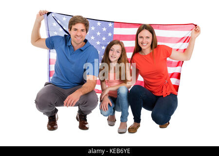 Lächelnd Familie Holding amerikanische Fahne auf weißem Hintergrund Stockfoto