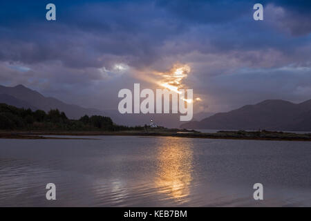 Dramatische dawn Licht und Sonnenstrahlen an ornsay Leuchtturm auf der Insel Eilean Sionnach aus der Halbinsel Sleat, Isle of Skye, Highland, Schottland, UK Stockfoto