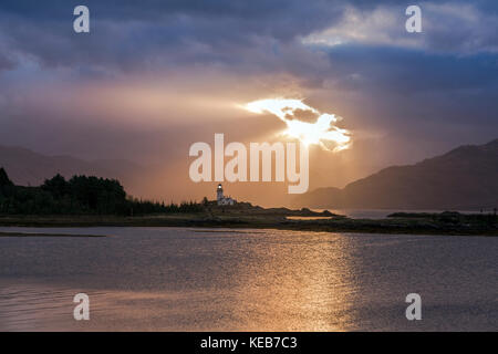 Dramatische dawn Licht und Sonnenstrahlen an ornsay Leuchtturm auf der Insel Eilean Sionnach aus der Halbinsel Sleat, Isle of Skye, Highland, Schottland, UK Stockfoto