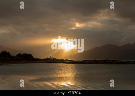 Dramatische dawn Licht und Sonnenstrahlen an ornsay Leuchtturm auf der Insel Eilean Sionnach aus der Halbinsel Sleat, Isle of Skye, Highland, Schottland, UK Stockfoto