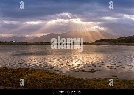 Dramatische dawn Licht und Sonnenstrahlen an ornsay Leuchtturm auf der Insel Eilean Sionnach aus der Halbinsel Sleat, Isle of Skye, Highland, Schottland, UK Stockfoto