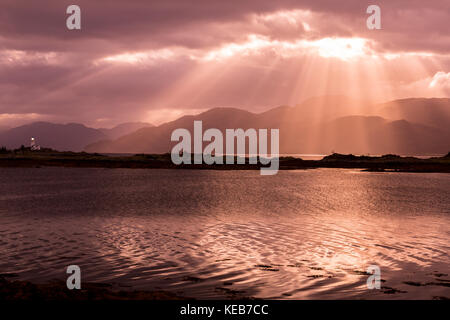 Dramatische dawn Licht und Sonnenstrahlen an ornsay Leuchtturm auf der Insel Eilean Sionnach aus der Halbinsel Sleat, Isle of Skye, Highland, Schottland, UK Stockfoto