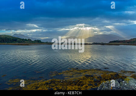 Dramatische dawn Licht und Sonnenstrahlen an ornsay Leuchtturm auf der Insel Eilean Sionnach aus der Halbinsel Sleat, Isle of Skye, Highland, Schottland, UK Stockfoto