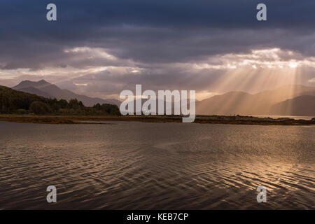 Dramatische dawn Licht und Sonnenstrahlen an ornsay Leuchtturm auf der Insel Eilean Sionnach aus der Halbinsel Sleat, Isle of Skye, Highland, Schottland, UK Stockfoto