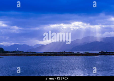 Dramatische dawn Licht und Sonnenstrahlen an ornsay Leuchtturm auf der Insel Eilean Sionnach aus der Halbinsel Sleat, Isle of Skye, Highland, Schottland, UK Stockfoto