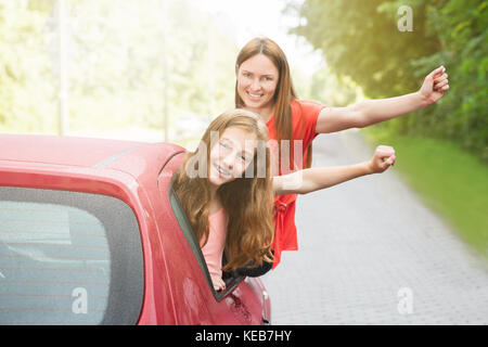 Glücklich lächelnde Mutter und Tochter Schiefen außerhalb des Auto Fenster Stockfoto