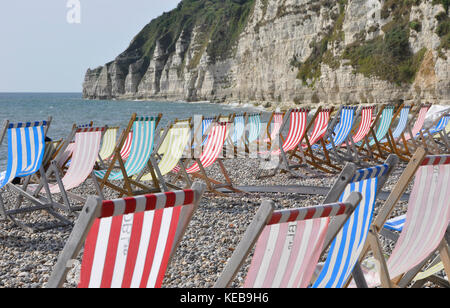 Liegestühle auf der Kiesstrand in Bier in Devon, Großbritannien. Stockfoto