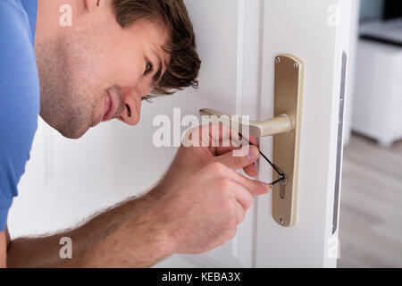 Nahaufnahme von jungen männlichen Lockpicker Öffnen der Tür verriegeln Stockfoto