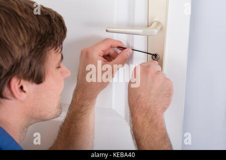 Nahaufnahme von jungen männlichen Lockpicker Öffnen der Tür verriegeln Stockfoto