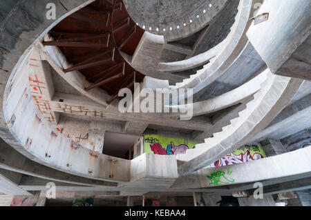 Eine konkrete Wendeltreppe in einem unfertigen, verlassenen Gebäude Stockfoto