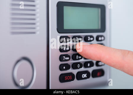 Close-up Person's Finger Einstellung Sicherheit Alarmanlage Stockfoto