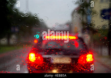 Wassertropfen auf dem Auto Glas. Blur, Bokeh und Straßenlaternen hinter sich. Stockfoto