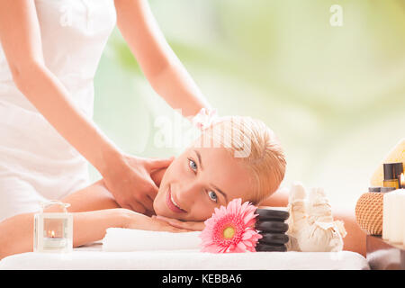 Junge Lächeln schönen blonden Frau liegen auf einem Massagetisch und Massage. Stockfoto