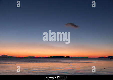 Das Ende der Sonnenuntergang und der Beginn der Dämmerung am See, mit großen, bunten Himmel und eine isolierte Red Cloud Stockfoto