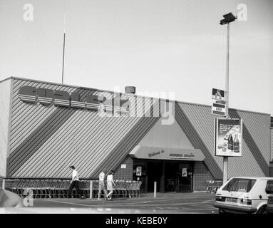 Ein Schwarzweiß-Bild zeigt den alten Curley's Supermarkt an der Andersonstown Road in Belfast, Nordirland. Das Gelände war früher eine Lucozade-Fabrik, die Hugh Kennedy 1981 kaufte, entwickelte und seinen Supermarkt Curleys eröffnete. Später wurde es 1991 von Kennedy als Kennedy Centre umgebaut. Kennedy Centre ist ein Einzelhandels- und Freizeitbaugebiet in einem weitgehend bebauten Wohngebiet im Westen von Belfast. Nachdem man sich auf einen neuen Ankermieter geeinigt hatte, wurde das Kennedy Centre 2009 erneut umgebaut. Mit einer Fläche von ca. 97.000 Quadratmetern ist der Ankermieter Sainsburys Supermarkt, Stockfoto