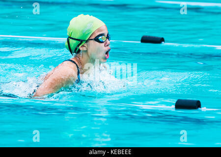 Chiang Mai, Thailand - 11. Oktober 2017 - Junge weibliche Schwimmer Rennen in Atem strich und wirft ihren Atem an einer Schule Schwimmbad in ch zu fangen Stockfoto