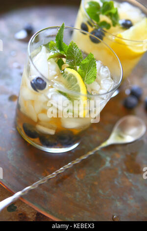 Zwei Gläser grüner Tee mit crushed Eis, Zitrone, frischen Blaubeeren und Minzeblättchen Stockfoto