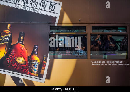 Passagiere, die auf einem Hong Kong tram Werbung Spirituosen Stockfoto