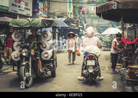 Die Einheimischen zu Fuß und Mopeds in einer Straße in der Altstadt von Hanoi Quartal Stockfoto