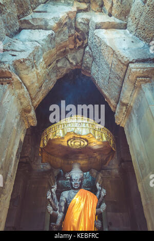 Eine Statue des Grundsatzes Gottheiten im Hinduismus, Vishnu von einer alten gewölbten Tür an Angkor Wat gerahmt Stockfoto