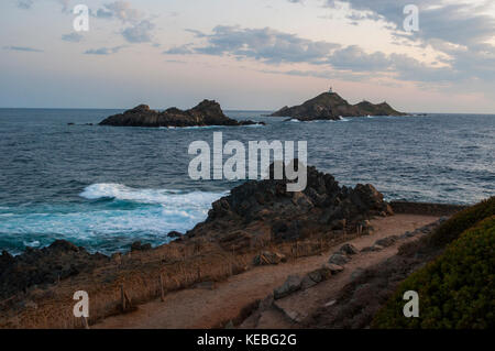 Korsika: ein rosa Sonnenuntergang auf den Iles Sanguinaires Inseln (blutigen), berühmten vier dunklen roten Porphyr Inseln im Golf von Ajaccio mit einem Leuchtturm dating 1844 Stockfoto