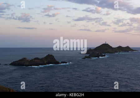 Korsika: ein rosa Sonnenuntergang auf den Iles Sanguinaires Inseln (blutigen), berühmten vier dunklen roten Porphyr Inseln im Golf von Ajaccio mit einem Leuchtturm dating 1844 Stockfoto