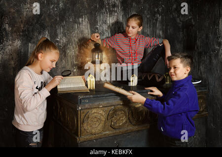 Drei Kinder in Quest Spiel ein Rätsel lösen. Stockfoto