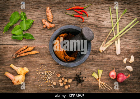 Auswahl an Thai food Zutaten zum Kochen und Würzen Red Curry Paste Wirkstoff von Thai beliebte Speisen auf rustikalen Holzmöbeln Hintergrund. Gewürze Zutaten Stockfoto