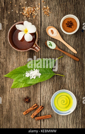 Avocados Blätter mit Nature Spa Zutaten getrocknete indischen bael, Zimtpulver, Zimtstangen, aromatische Öl, Sternanis und Meersalz auf rustikalen Bac Stockfoto