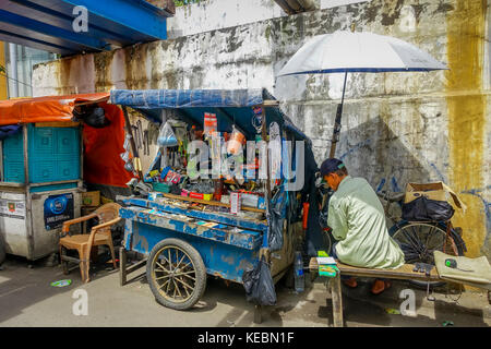 Jakarta, Indonesien - 3. März, 2017: lokale Mann sitzt neben seinem kleinen Markt Trolley, Verkauf von Hardware Werkzeuge und Produkte Stockfoto