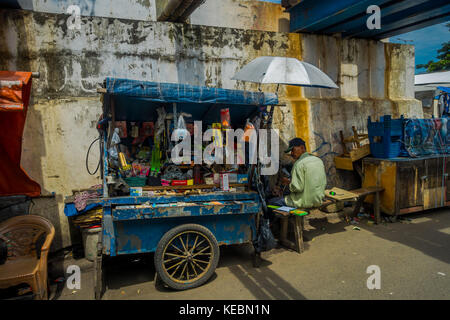 Jakarta, Indonesien - 3. März, 2017: lokale Mann sitzt neben seinem kleinen Markt Trolley, Verkauf von Hardware Werkzeuge und Produkte Stockfoto