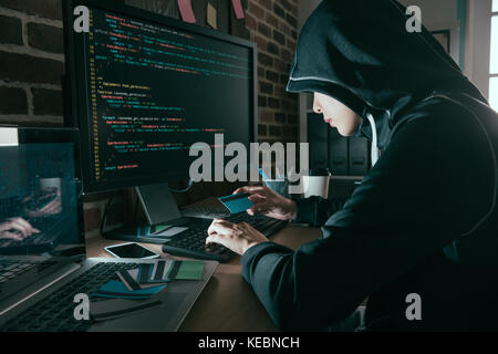 Hübsche junge hackerin gestohlenen Kreditkarte Informationen und über Eigengeschäfte durch online-Forschung. Stockfoto