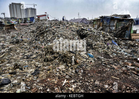 Jakarta, Java, Indonesien. August 2016. Plastik- und Holzhäuser sind über den Ruinen und Müll im Pasar Ikan Stadtteil Jakarta gebaut. Im April letzten Jahres stürmten Hunderte von Soldaten und Polizisten Pasar Ikan, ein historisches Fischerviertel nördlich von Jakarta, und machten alles in Trümmer. Wo es Backsteinhäuser gab, jetzt gibt es Berge von Schutt und Zelten. Die Einwohner zögern, die Nachbarschaft zu verlassen und weigern sich, in die von den Behörden gewährten Schutzhütten zu ziehen, weil sie behaupten, sie könnten sich diese nicht leisten. Das sind Vertreibungen mit Stockfoto