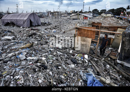 Jakarta, Java, Indonesien. August 2016. Ein Mann wird gesehen, wie er sein Haus mit Resten aus Holz und Plastik in der Nachbarschaft Pasar Ikan in Jakarta baute. Im April letzten Jahres stürmten Hunderte von Soldaten und Polizisten Pasar Ikan, ein historisches Fischerviertel nördlich von Jakarta, und machten alles in Trümmer. Wo es Backsteinhäuser gab, jetzt gibt es Berge von Schutt und Zelten. Die Einwohner zögern, die Nachbarschaft zu verlassen und weigern sich, in die von den Behörden gewährten Schutzhütten zu ziehen, weil sie behaupten, sie könnten sich diese nicht leisten. Sie sind Räumungen Stockfoto