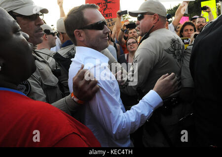 Gainesville, Florida, USA. 19 Okt, 2017. Ein Anhänger des weißen nationalistischen Richard Spencer von der Polizei für seine eigene Sicherheit begleitet ist, wie er an die Demonstranten nach der Spencer Rede an der Universität von Florida am 19. Oktober 2017 in Gainesville, Florida. Hunderte von Polizeibeamten waren an Hand der Demonstranten zu steuern. Credit: Paul Hennessy/alamy leben Nachrichten Stockfoto