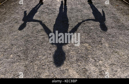 München, Deutschland. Oktober 2017. Der Schatten einer Frau mit ihren beiden Kindern ist auf einem Weg im Münchner Hofgarten zu sehen, 20. Oktober 2017: Peter Kneffel/dpa/Alamy Live News Stockfoto