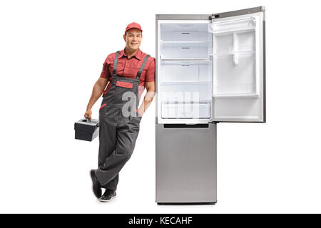 In voller Länge Porträt der Handwerker mit einer Toolbox vor einem offenen Kühlschrank auf weißem Hintergrund schiefen Stockfoto