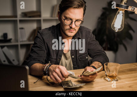 Schöner Mann zählen Bargeld Stockfoto