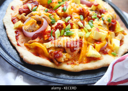 Hausgemachte Pizza mit Huhn, Zwiebeln, Paprika, Frühlingszwiebeln, Käse und Barbecue Sauce Stockfoto