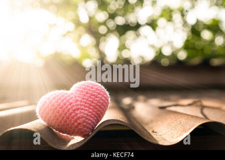 Rosa Herz Stricken auf dem Dach in Morgen Sonne. Stockfoto