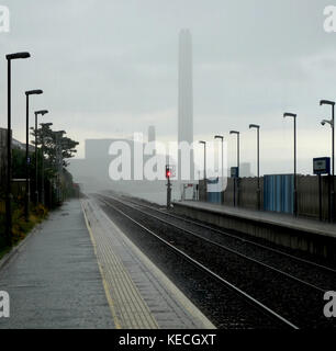 Nassen Tag auf Downshire Bahnhof, Kilroot power station in der Entfernung Stockfoto