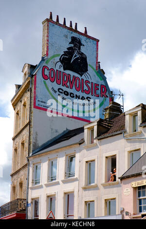 Alte Courvoisier Brandy Anzeige auf der Seite eines Hauses in Quai de Caligny, Cherbourg, Normandie, Frankreich Stockfoto