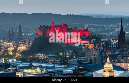 Blick auf das Edinburgh Castle, das am Abend von den Salisbury Crags in Edinburgh, Schottland, Großbritannien, rot beleuchtet wird. Stockfoto