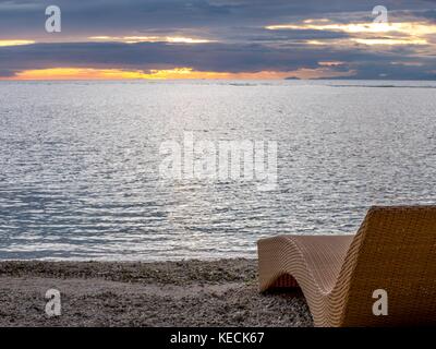 Strandkorb am Strand mit Blick auf Meer, Sonnenuntergang Strand. Sommerurlaub und Urlaub Stockfoto