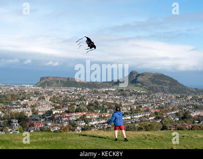 Blick auf den Jungen fliegenden Drachen und die Salisbury Crags und Arthur's Seat Hill mit Blick auf Edinburgh, Schottland, Großbritannien Stockfoto