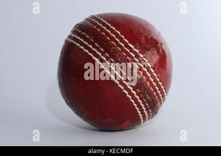 Nahaufnahme von einem klassischen roten Englisch Cricket Ball auf weißem Hintergrund Stockfoto