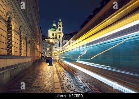 Nacht der Verkehr auf der alten Straße in der Nähe der Kirche des Heiligen Nikolaus in Prag, Tschechische Republik. Stockfoto